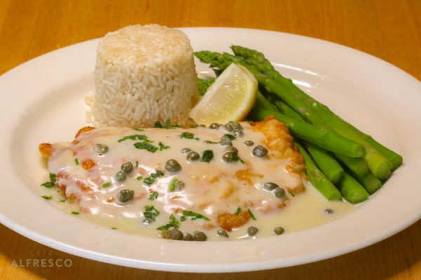 A plate of grouper Francese, served with rice and asparagus.