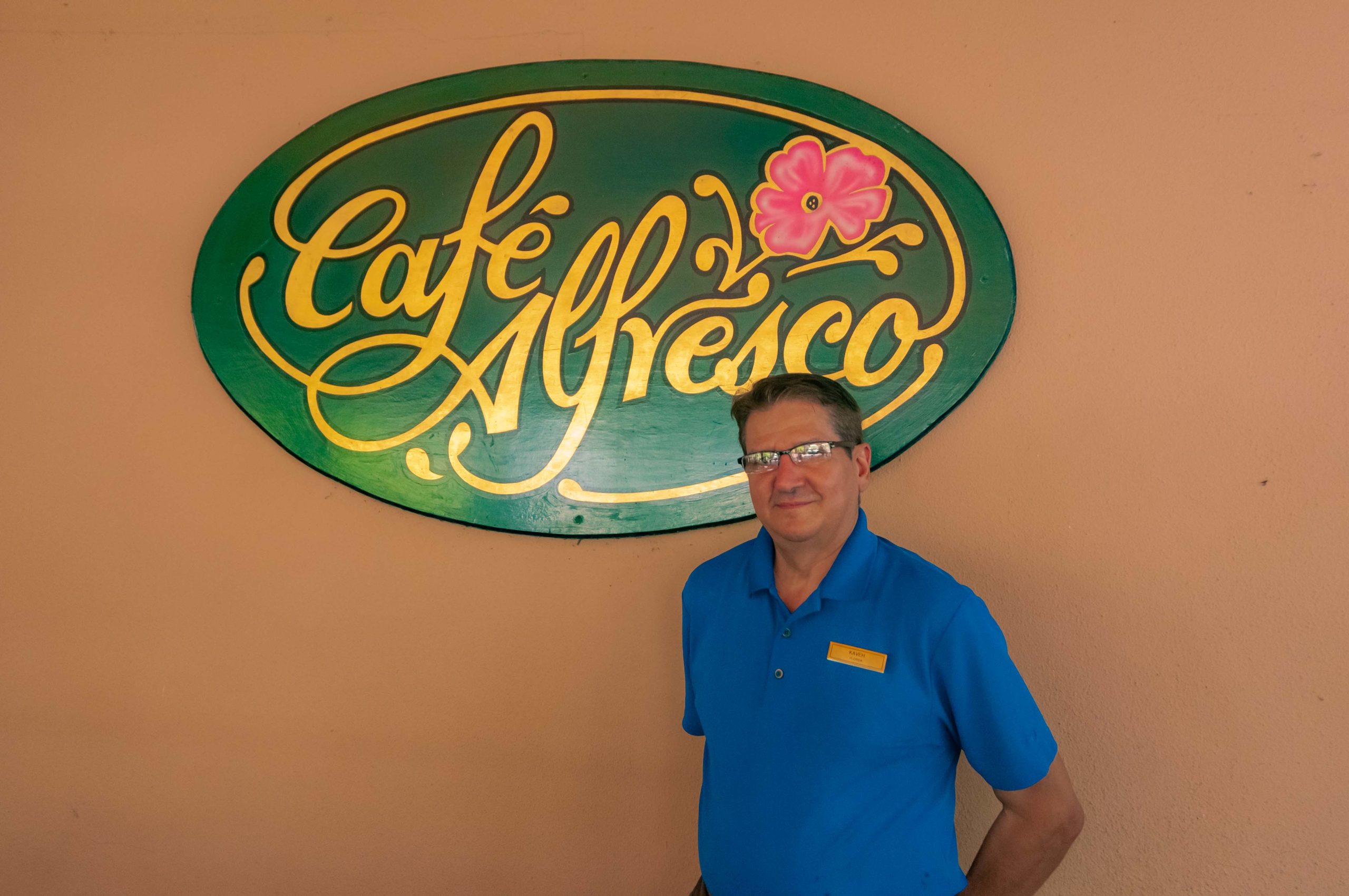Kaveh stands in front of the Café Alfresco sign