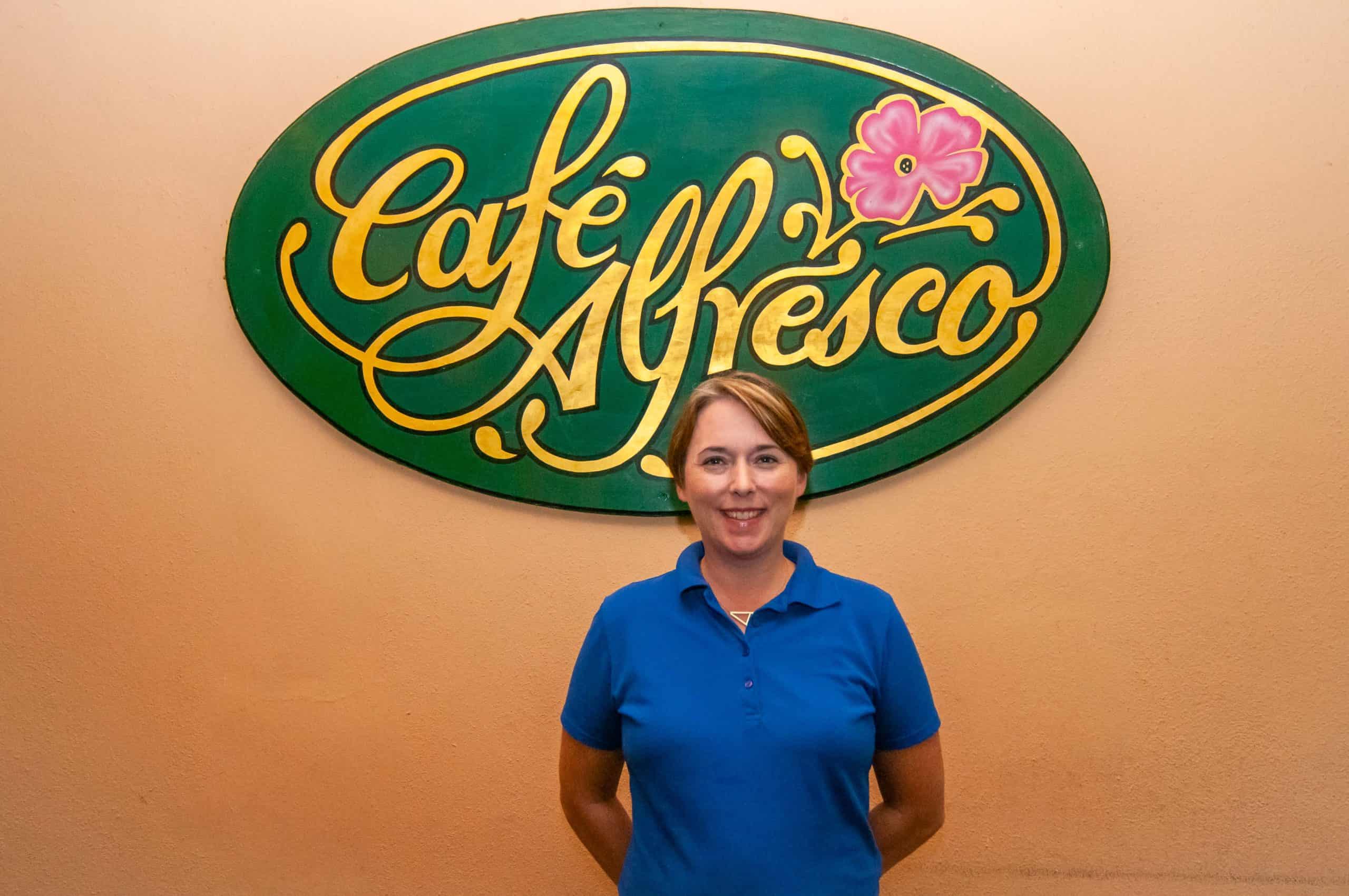 Ann standing in front of the Café Alfresco sign on the patio